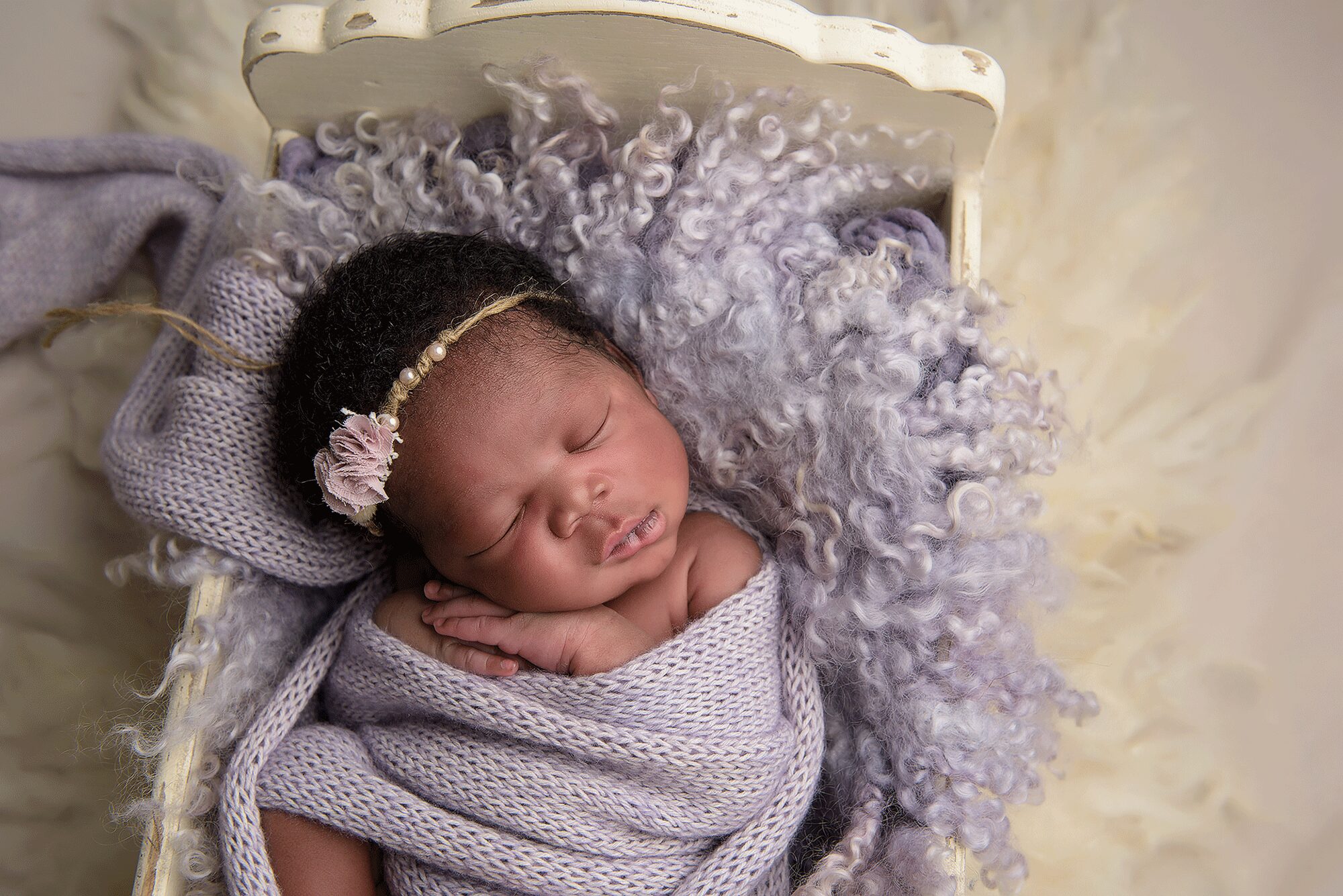 Baby Girl in Creme Bed and Purple Wrap